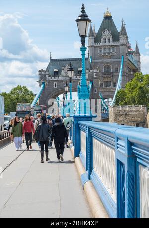 La gente è in giro in una soleggiata giornata d'estate a piedi sul Tower Bridge. Londra, Inghilterra, Regno Unito Foto Stock