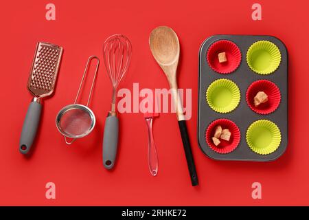 Forme e utensili da forno su sfondo rosso Foto Stock