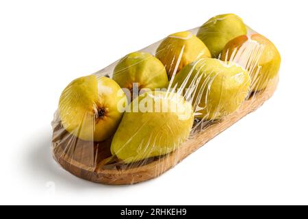 Tavola di legno di pere fresche ricoperta da involucro di plastica su sfondo bianco Foto Stock