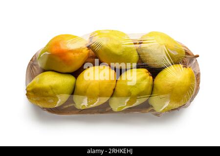 Tavola di legno di pere fresche ricoperta da involucro di plastica su sfondo bianco Foto Stock