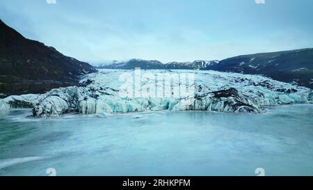 Fatto il colpo di lago ghiacciato con blocchi di ghiaccio, ghiacciaio vatnajokull che galleggia nelle acque nordiche in islanda. Paesaggio di ghiaccio naturale con iceberg e rocce ghiacciate, montagne e colline. Rallentatore. Foto Stock