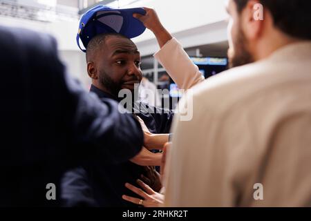 Gli acquirenti si comportano in modo scortese nei confronti del personale addetto alla sicurezza nel centro commerciale durante il Black Friday. Folle e aggressivo che litiga e combatte con la polizia mentre cerca offerte e occasioni migliori Foto Stock