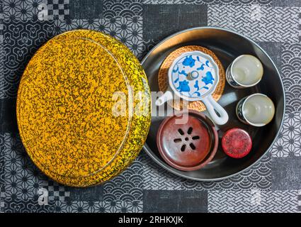 Vista dall'alto di un set da tè giapponese con tazze Chawan in ceramica, una teiera e un recipiente chakoboshi per raccogliere il tè in eccesso, conservato in un oro Foto Stock