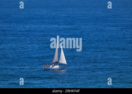 Barca a vela in cabina sull'Oceano Azzurro aperto Foto Stock