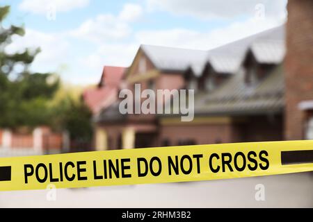 Nastro giallo della scena del crimine che blocca la strada Foto Stock