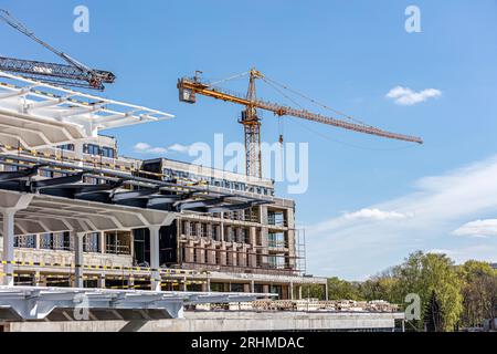 cantiere edile con gru a torre gialla contro il cielo azzurro. Foto Stock