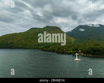 Una grande croce nelle acque turchesi dell'isola di Camiguin. Cimitero sommerso. Filippine. Foto Stock