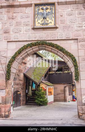 Punto di riferimento di Norimberga. Arco fino alla città vecchia di Norimberga. Porta della città con stemma imperiale. Architettura medievale. Ingresso a Handwerkerhof. Foto Stock