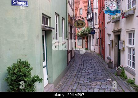 Stretta strada nel quartiere storico Schnoor di Brema. Città vecchia vuota con negozi e case a Brema. Edifici medievali con fiori sulle pareti. Foto Stock