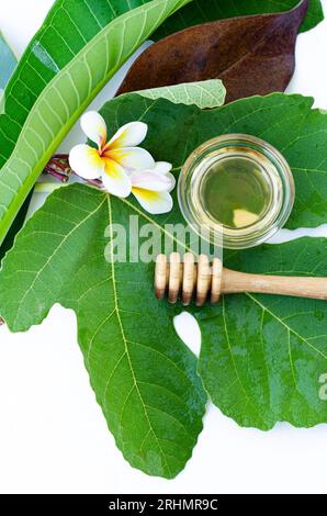 Cucchiaio di miele con miele e un fiore di frangipani Foto Stock