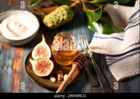 Delizioso miele greco di Rodi con fichi e una ciotola di yogurt Foto Stock