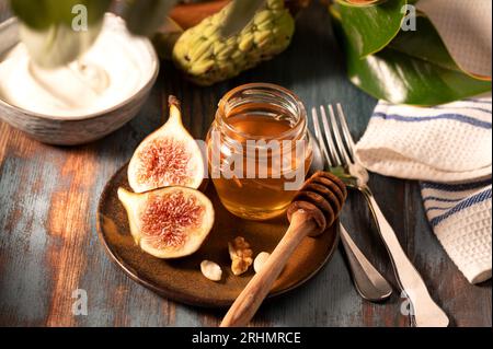 Delizioso miele greco di Rodi con fichi e una ciotola di yogurt Foto Stock