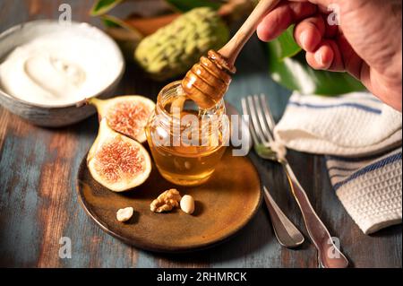 Delizioso miele greco di Rodi con fichi e una ciotola di yogurt Foto Stock