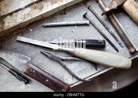 Riparazione del vecchio finestrino danneggiato o smontaggio prima di installare il nuovo primo piano. Riparazione di un telaio di una finestra, utilizzando strumenti per la ristrutturazione di vecchie finestre Foto Stock