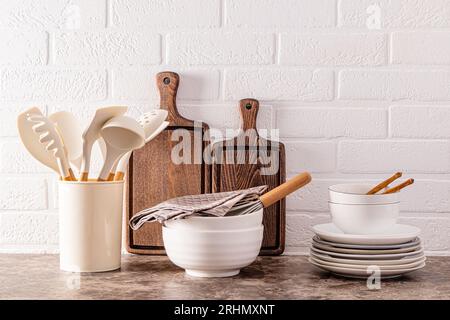 Cucina moderna ed elegante. Oggetti e utensili ecologici su un ripiano in marmo scuro all'interno di un'accogliente cucina Foto Stock