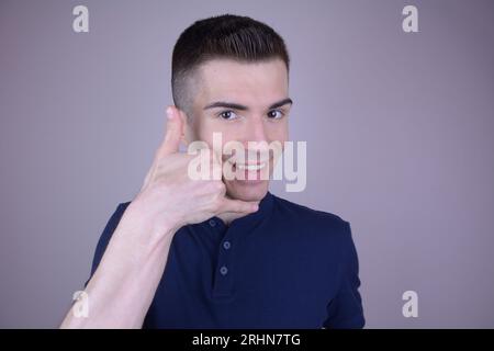 Giovane bell'uomo caucasico fa "Call me" gesto con la mano su sfondo isolato Foto Stock