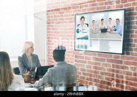 Un gruppo di imprenditori aventi Video conferenza nella sala riunioni Foto Stock