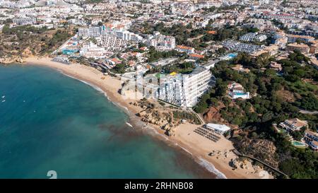 Foto aerea della bellissima città di Albufeira in Portogallo che mostra la spiaggia di sabbia dorata di Praia da Oura, con alberghi e appartamenti in città, scattata Foto Stock