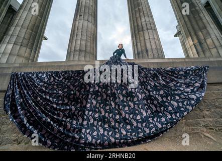 Jonny Hawkins interpreta "Maureen", protagonista dello spettacolo omonimo al National Monument di Calton Hill durante il Festival Fringe di Edimburgo. Lo spettacolo, che viene eseguito presso la Casa di Oz del festival, celebra la saggezza e la passione delle donne anziane che sfidano l'invisibilità, presenta un palcoscenico interamente ripreso dalla favolosa gonna grande del personaggio. Data immagine: Venerdì 18 agosto 2023. Foto Stock