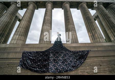 Jonny Hawkins interpreta "Maureen", protagonista dello spettacolo omonimo al National Monument di Calton Hill durante il Festival Fringe di Edimburgo. Lo spettacolo, che viene eseguito presso la Casa di Oz del festival, celebra la saggezza e la passione delle donne anziane che sfidano l'invisibilità, presenta un palcoscenico interamente ripreso dalla favolosa gonna grande del personaggio. Data immagine: Venerdì 18 agosto 2023. Foto Stock