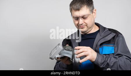 Un uomo tiene una semimaschera respiratoria per proteggere da polvere e gas. Foto Stock