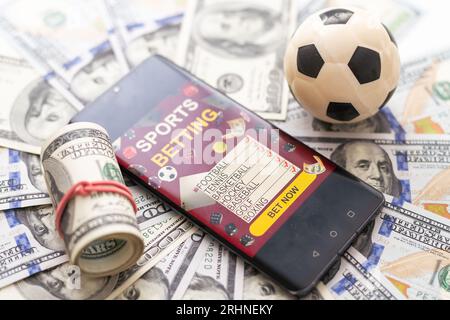Scommesse sul calcio su cellulare. Note sul calcio e sul franco gibutiano sullo schermo del telefono. Campo da calcio sullo schermo dello smartphone isolato su sfondo bianco. scommetti Foto Stock