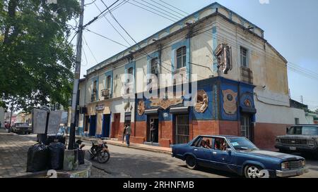 Foto che mostra la vita pubblica in una strada della città di Calabozo in Venezuela, raffigurata che mostra alcuni vecchi edifici, vecchie auto e persone. Foto Stock