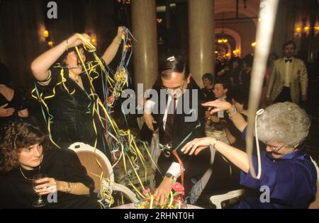 Festa della vigilia di Capodanno al Ritz Hotel London England 1980 coppia che si diverte a festeggiare con i coloratissimi streamer a mezzanotte 1986 Dinner Dance presso un hotel di Londra New Years Celebrations. UK HOMER SYKES Foto Stock