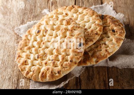 Primo piano del pane pita rotondo fatto in casa su un tavolo di legno. Orizzontale Foto Stock