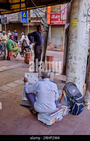 India, nuova Delhi, vecchia Delhi, uomo che legge il giornale per strada Foto Stock
