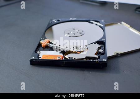 Dettaglio di un disco fisso per notebook evidenziato, a simboleggiare il supporto tecnico e il progresso tecnologico. Concetto tra assistenza tecnica e tecnologia Foto Stock