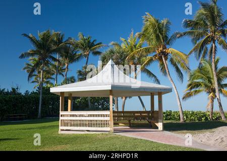 Naples, Florida, USA. Tipico gazebo in legno sotto le torreggianti palme sulla spiaggia nel Lowdermilk Park. Foto Stock