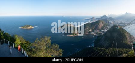 Rio de Janeiro, Brasile: La funivia del Pan di zucchero e la splendida vista panoramica dello skyline della città con montagne, spiagge e quartieri Foto Stock