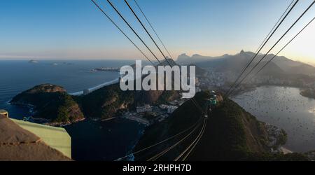 Rio de Janeiro, Brasile: La funivia del Pan di zucchero e la splendida vista panoramica dello skyline della città con montagne, spiagge e quartieri Foto Stock