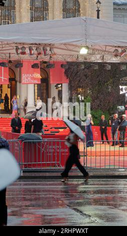 Gli ospiti arrivano sul tappeto rosso sotto la pioggia per il Sarajevo Film Festival, Festival Square, Sarajevo, Bosnia ed Erzegovina, 18 agosto, 2023 Foto Stock