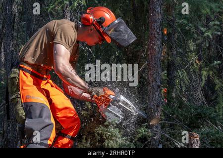 (230818) -- NORTHWEST TERRITORIES (CANADA), 18 agosto 2023 (Xinhua) -- foto scattata il 16 agosto 2023 mostra un membro delle forze armate canadesi che costruiscono una fuga di fuoco a Yellowknife, Northwest Territories, Canada. Il governo dei territori del Nord-Ovest del Canada ha dichiarato lo stato di emergenza martedì e ha emesso l'ordine di evacuazione mercoledì in risposta a incendi fuori controllo. È in corso l'evacuazione di massa delle aree del territorio, compresa la capitale Yellowknife, la più grande comunità del territorio con una popolazione di oltre 20.000. Ai residenti fu ordinato di andarsene entro mezzogiorno Foto Stock