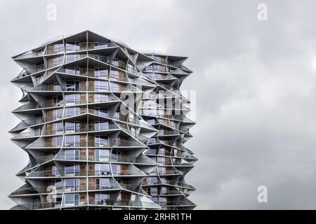 Alto e moderno edificio residenziale affacciato su un cielo grigio. Cactus Tower a Copenhagen, Danimarca Foto Stock