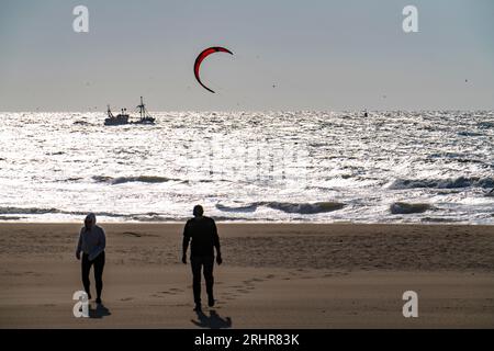 Kitesurf e barche per gamberi al largo della costa di Scheveningen, passeggini sulla spiaggia, l'Aia, Paesi Bassi Foto Stock