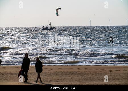 Kitesurf e barche per gamberi al largo della costa di Scheveningen, passeggini sulla spiaggia, l'Aia, Paesi Bassi Foto Stock