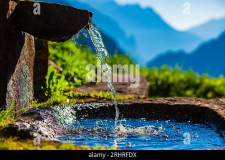 Sorgente d'acqua sullo sfondo delle montagne alpine Foto Stock