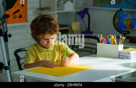 Torna a scuola. Scolaro che fa i compiti scolastici per la scuola elementare. Carino allievo che fa i compiti, scrive e legge. Bambino della scuola elementare Foto Stock