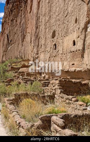 Rovine di fondamenta in pietra prima di incisioni rupestri scavate nelle pareti del canyon rivestite di tufo di cenere vulcanica dagli antichi abitanti delle scogliere puebloane Foto Stock