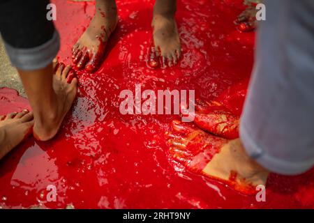 I musulmani immergono i piedi nel sangue dopo aver massacrato un animale per strada a Dacca per il più grande festival musulmano Eid-ul-Azha noto anche come Eid Foto Stock