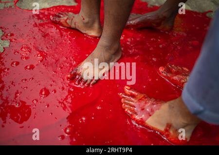 I musulmani immergono i piedi nel sangue dopo aver massacrato un animale per strada a Dacca per il più grande festival musulmano Eid-ul-Azha noto anche come Eid Foto Stock