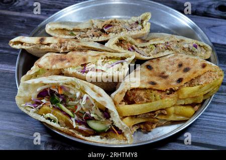 Patate fritte sandwich a dita e pane piatto con purè di fave e tradizionali panini egiziani con dinamite farciti di fave, uova, gre Foto Stock