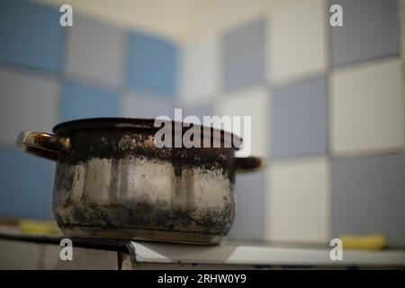 Vecchia padella sul lavandino. Piatti in cucina. Vecchia cucina in casa. Pentola bruciata. Foto Stock