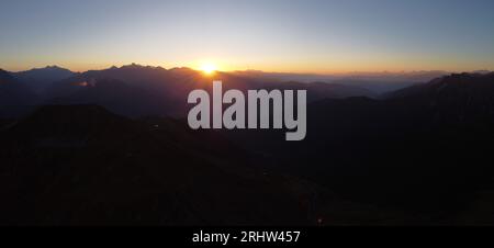 Sonnenaufgang hoch auf den Bergen - Sonnenaufgang am Gipfelkreuz Foto Stock