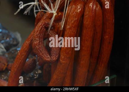 Capanne affumicate di salsicce al mercato. Prodotti semilavorati. Pronti a mangiare. Foto Stock