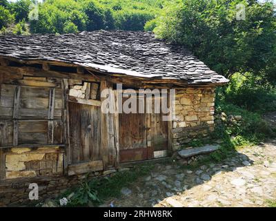Un vecchio capanno idilliaco e logoro in un remoto villaggio nel nord della Macedonia. Foto Stock