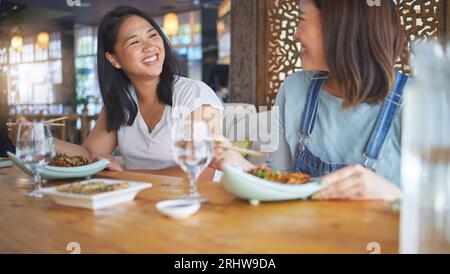 Sushi, ristorante e donne amiche di noodle, bacchette e piatto di pesce. Pranzo, donna asiatica affamata e pasto cinese con un amico felice Foto Stock